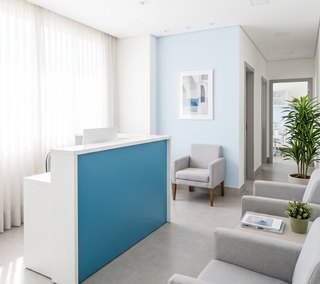 Recepção da Care Dental, com balcão de atendimento e poltronas da sala de espera